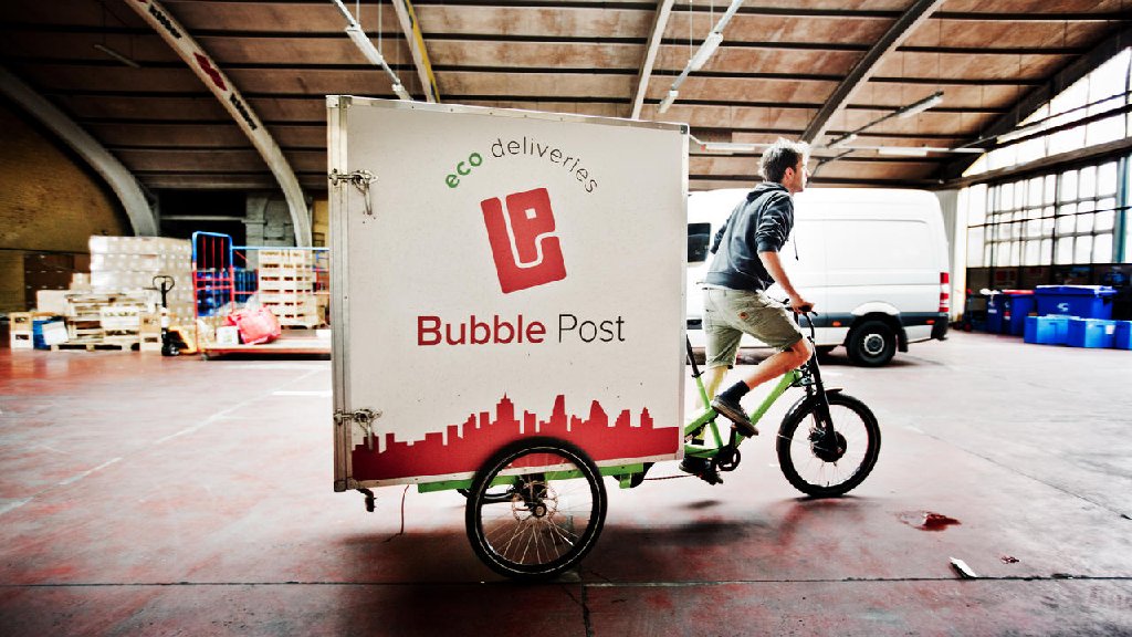 Cargo bike driver with Bubble Post branding is ready to navigate the city while using the route planning software that lives on as the start-up Dropon.